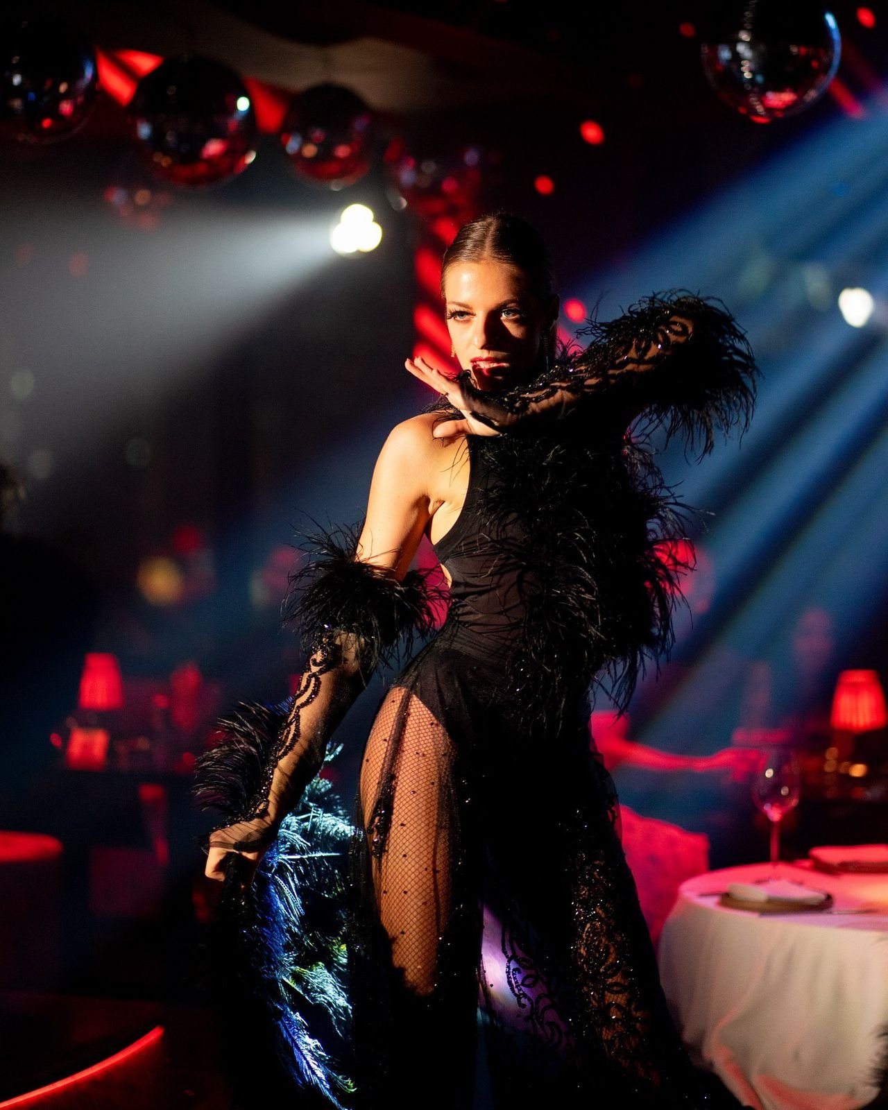 Female dancer performing in a black feather costume at a Showciety live entertainment event